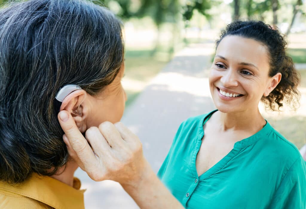 Woman using her hearing aid to help her communicate with her neighbor